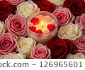 candle featuring floating miniature rose petals, surrounded by vibrant pink and red roses, creating a romantic and luxurious ambiance perfect for relaxation 126965601
