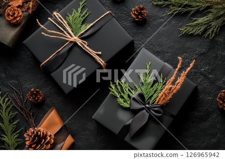 Black Gift Boxes Arranged on Textured Dark Stone Surface With Elegant Ribbons. 126965942