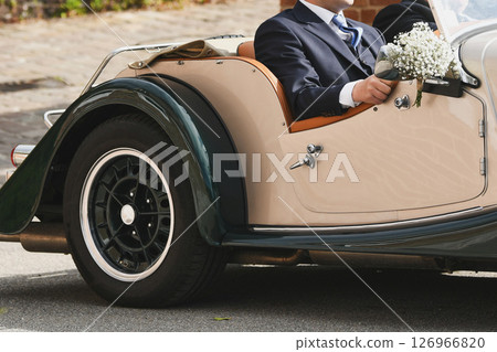 Groom in a vintage convertible retro car at a wedding. 126966820