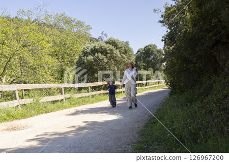 Mother and son walking on a country road in springtime Mother and son walking on a country road in springtime 126967200