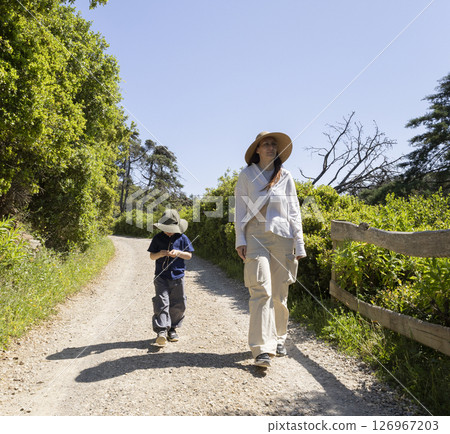 Mother and son hiking on sunny summer day in nature reserve Mother and son hiking on sunny summer day in nature reserve 126967203
