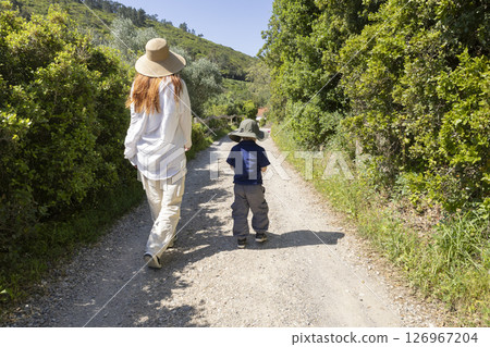 Mother and son walking on country road enjoying sunny day Mother and son walking on country road enjoying sunny day 126967204