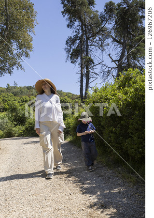 Mother and son hiking on sunny summer day in nature preserve 126967206