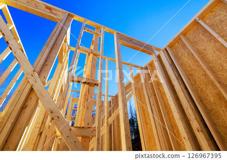 Builders are assembling wooden beams frames for new house at construction zone 126967395
