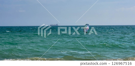 Sea sports Windsurfing. Surfer, surfing on the water in the sea on a sunny day 126967516