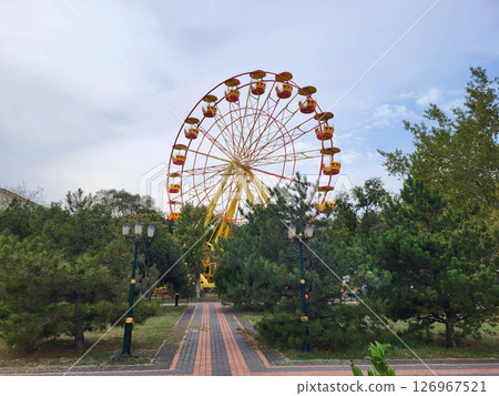 Ferris wheel surrounded by trees in Kerch. 126967521