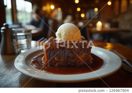 Sticky Toffee Pudding and Ice Cream in Candlelit English Country Pub 126967804