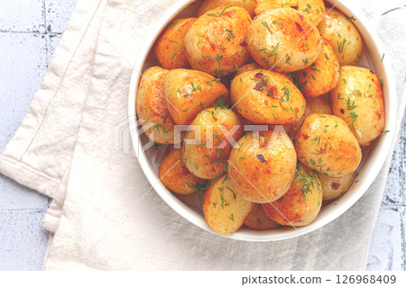 Baked new potatoes, with butter and dill, on a white plate, at home, no people, 126968409