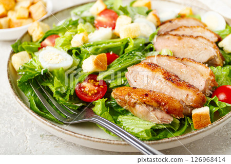 Caesar salad, with duck breast, on a light plate, on a light background, homemade, no people, 126968414