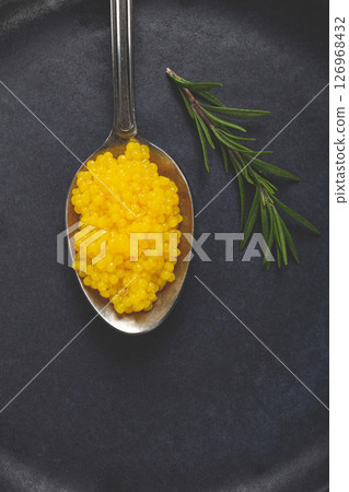pearl yuzu, yuzu caviar - pearl, on a spoon, top view, on a dark gray plate, there are no people. 126968432