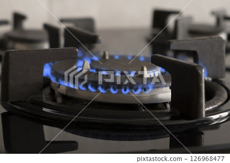 Blue fire from domestic kitchen stove top. Gas cooker with burning flames. Blue fire from domestic kitchen stove top. Gas cooker with burning flames. 126968477
