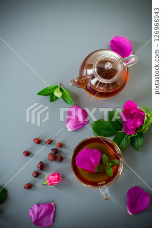 Herbal rosehip and mint tea in a cup and teapot from above Herbal rosehip and mint tea in a cup and teapot from above 126968943