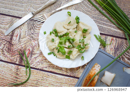 Delicious Ukrainian dumplings with steam and green onions Delicious Ukrainian dumplings with steam and green onions 126968947