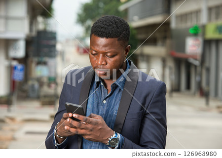 Man in business suit is enjoying modern mobile technologies. 126968980