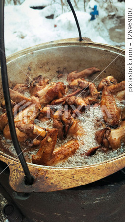 chicken wings are fried in oil in a cauldron 126969002