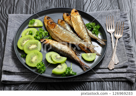 Hot smoked Baltic herrings with kiwi fruit slices 126969283