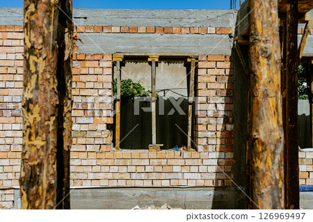 Single-family house construction site. Construction of a brick house with a wooden roof truss. High quality photo 126969497