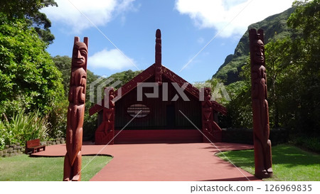 Traditional Maori meeting house with intricate carvings in lush surroundings 126969835