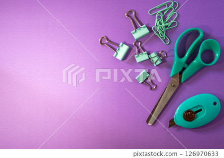Top view of organized school supplies on minimalist purple background. 126970633