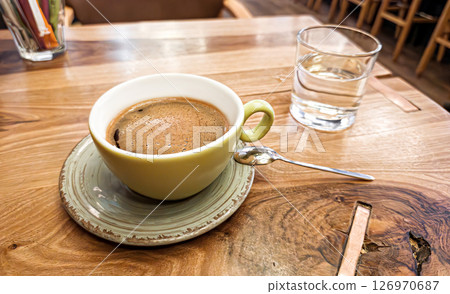 Green Coffee Cup on Wooden Cafe Table Green Coffee Cup on Wooden Cafe Table 126970687