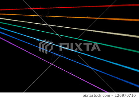 multicolored sewing threads in the form of a rainbow on a black background multicolored sewing threads in the form of a rainbow on a black background 126970710