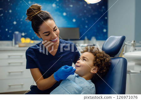 A woman is helping a child in a dentist's office 126971076