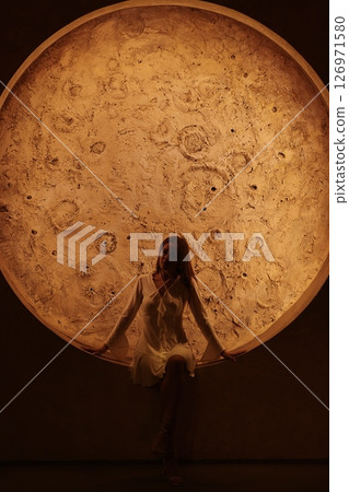 Experience an incredibly captivating view of a stunning celestial body with a figure above it Experience an incredibly captivating view of a stunning celestial body with a figure above it 126971580
