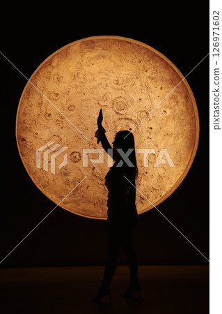 A Beautiful Silhouette Captured Against the Majestic Light of the Enchanting Moon A Beautiful Silhouette Captured Against the Majestic Light of the Enchanting Moon 126971602
