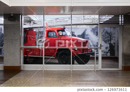A Vintage Red Fire Truck is Beautifully Displayed Against a Backdrop of Modern Architecture 126971611