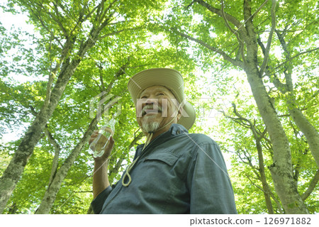 Elderly people bathing in the forest stay hydrated to prevent heatstroke Elderly people bathing in the forest stay hydrated to prevent heatstroke 126971882