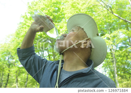 Elderly people bathing in the forest stay hydrated to prevent heatstroke 126971884