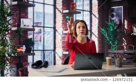 Mature freelancer reviewing holographic images with digital AI innovation, looking at the hologram projection at her home. Woman employs the artificial intelligence visualization. Camera B. Mature freelancer reviewing holographic images with digital AI innovation, looking at the hologram projection at her home. Woman employs the artificial intelligence visualization. Camera B. 126972151