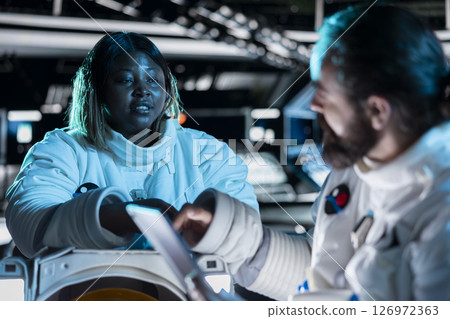 Cosmonauts preparing for planetary mission outside, gathering samples for study. Orbital station talking, beginning landing procedures on solar system planet, deepening understanding of universe Cosmonauts preparing for planetary mission outside, gathering samples for study. Orbital station talking, beginning landing procedures on solar system planet, deepening understanding of universe 126972363