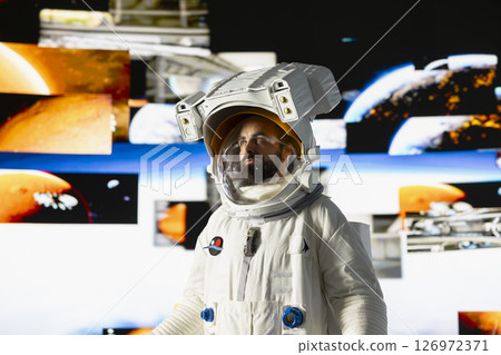 Male astronaut in a space suit floats in orbit above Earth, symbolizing the journey of humanity into cosmos. Endless pursuit of discovery, technology and exploring the unknown universe. 126972371