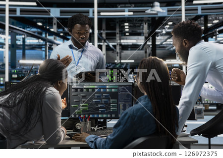 Data center system administrators using PC to visualize artificial intelligence neural networks made up of interconnected nodes. Server farm coworkers doing brainstorming, overseeing AI systems Data center system administrators using PC to visualize artificial intelligence neural networks made up of interconnected nodes. Server farm coworkers doing brainstorming, overseeing AI systems 126972375