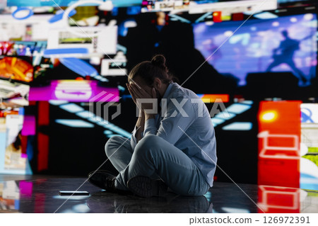 Paranoid guy suffers from emotional damage caused by obsessive social media use. Young man being overwhelmed by excessive information and comparison affecting his self esteem, manipulation. Paranoid guy suffers from emotional damage caused by obsessive social media use. Young man being overwhelmed by excessive information and comparison affecting his self esteem, manipulation. 126972391