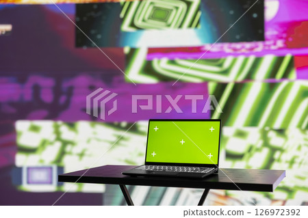 Wireless pc running chroma key display surrounded by colorful visual art clips, glowing in the dark and showcasing a clubbing atmosphere. Nightlife ambiance with urban lights and vibes. Wireless pc running chroma key display surrounded by colorful visual art clips, glowing in the dark and showcasing a clubbing atmosphere. Nightlife ambiance with urban lights and vibes. 126972392