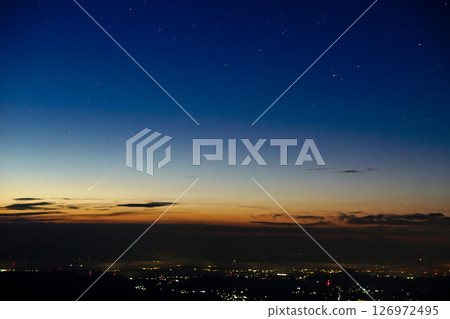 A comet appears in the night sky at dawn 126972495