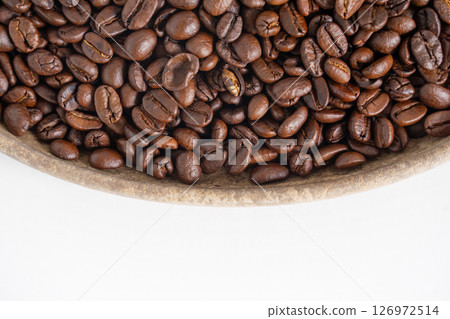 Coffee beans and wooden plate on white. Top view of brown roasted coffee beans. Close up image. Coffee beans and wooden plate on white. Top view of brown roasted coffee beans. Close up image. 126972514
