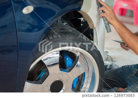 Checking car body work fiber bumper at car garage 126973083