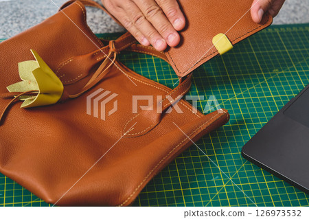 Artisan showing leather pocket detail on handmade bag Artisan showing leather pocket detail on handmade bag 126973532