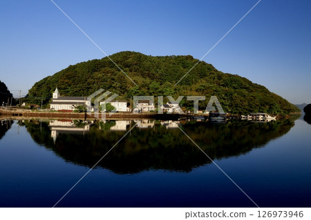 Morning on the island reflected on the sea surface Morning on the island reflected on the sea surface 126973946