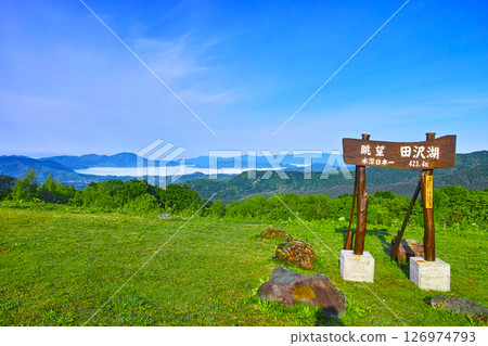 秋田縣仙北市的田澤湖遠景，清晨的田澤湖被一片新綠和夢幻般的雲海包圍著，旁邊還有招牌 126974793