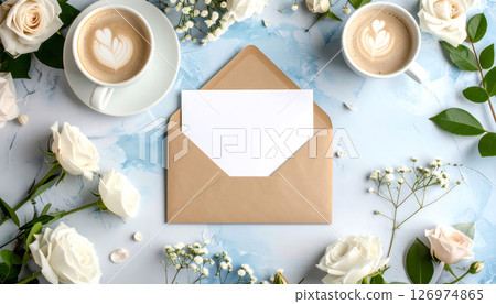 Coffee cups, envelope, blank card, and white flowers on a textured blue background, top view. Coffee cups, envelope, blank card, and white flowers on a textured blue background, top view. 126974865