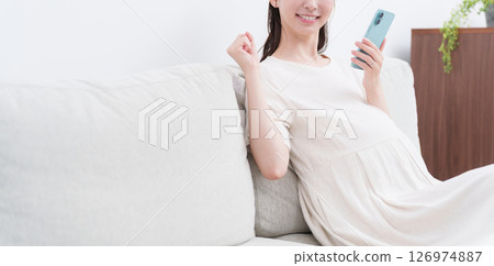 Pregnant woman using a smartphone (fist pump) Pregnant woman using a smartphone (fist pump) 126974887