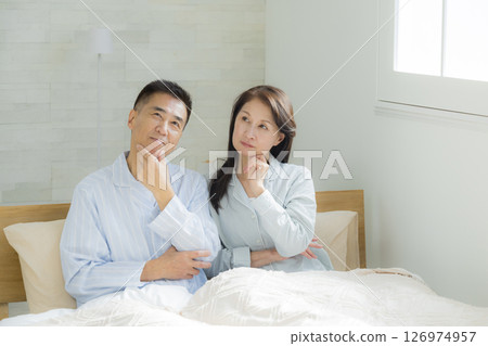 Middle-aged couple having a conversation in the bedroom Middle-aged couple having a conversation in the bedroom 126974957