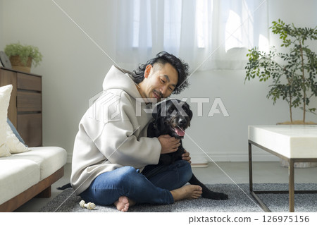 A man relaxing in the living room with his dog 126975156