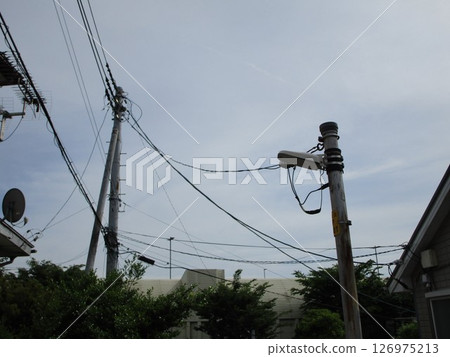 A power transmission tower and residential area towering against the winter sky 126975213