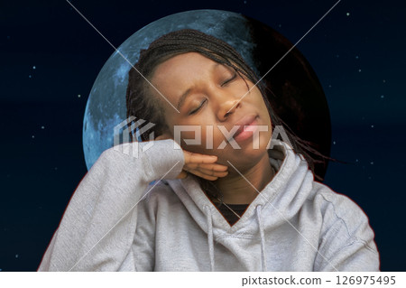 Sleeping African Woman in Hoodie with Moon Background at Night 126975495