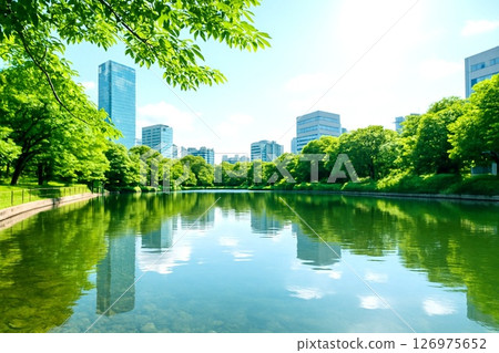 Image of a large artificial pond in a city of buildings surrounded by fresh greenery Image of a large artificial pond in a city of buildings surrounded by fresh greenery 126975652